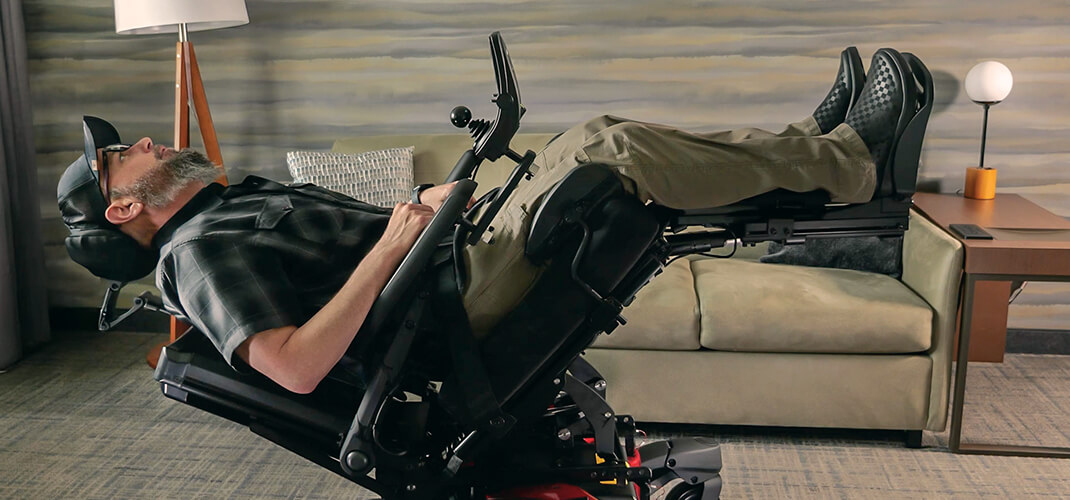 Un homme ajuste la position électrique de son fauteuil roulant grâce à la commande vocale.